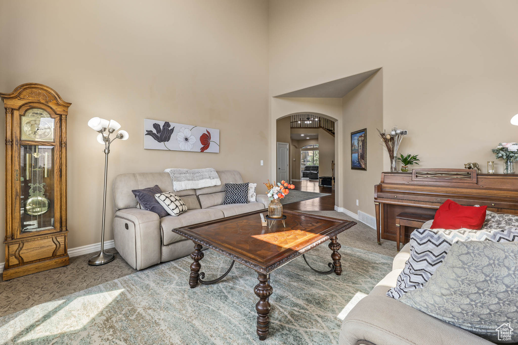 Living room featuring arched walkways and a towering ceiling