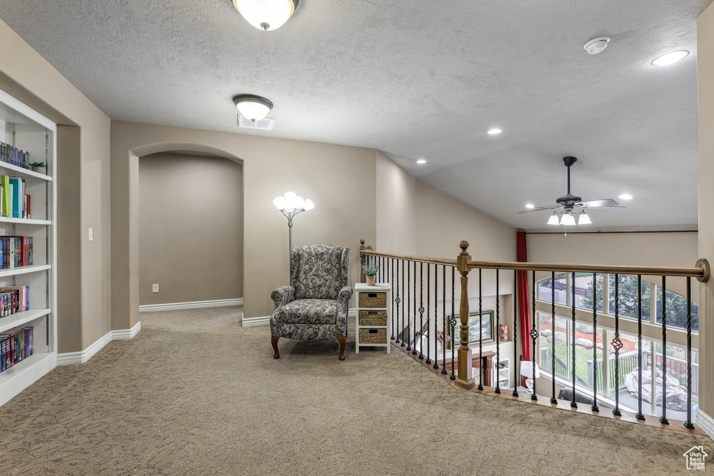 Living area featuring a ceiling fan, carpet floors, arched walkways, a textured ceiling, and recessed lighting