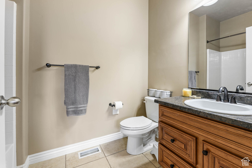 Bathroom with tile patterned flooring, vanity, and a shower