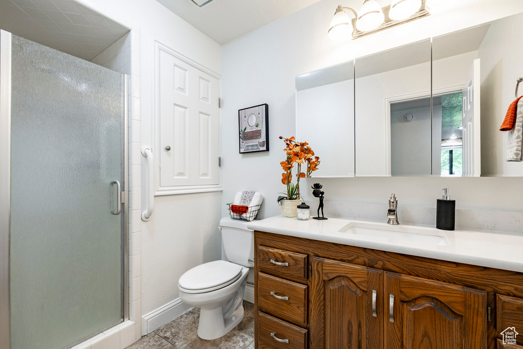 Bathroom featuring vanity, a shower stall, and tile patterned flooring
