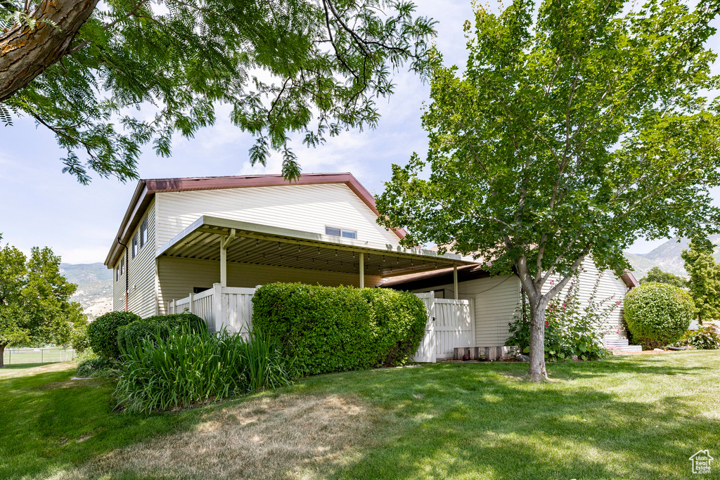 View of side of home with a yard and a mountain view