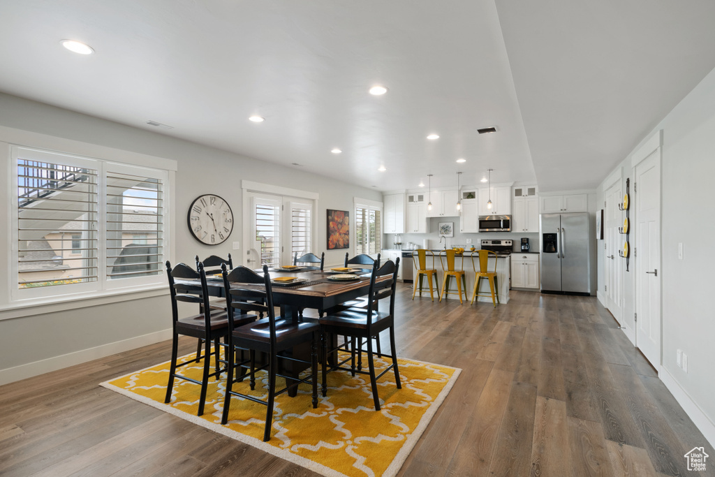 Dining area with dark wood-style floors and recessed lighting