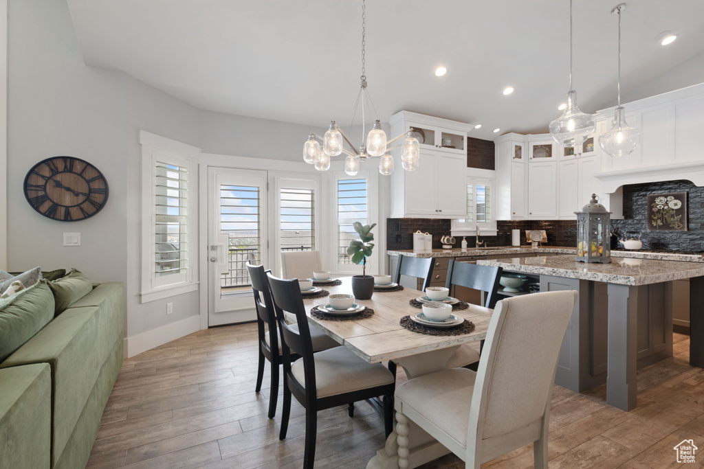 Dining space with light wood finished floors, recessed lighting, and a chandelier