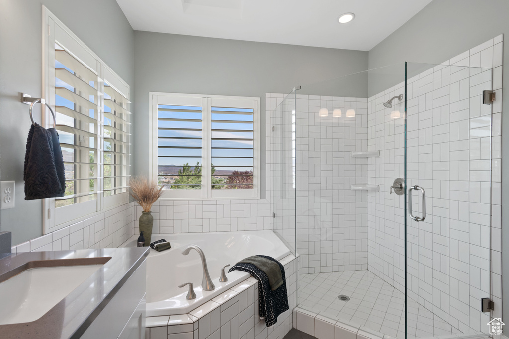 Bathroom featuring a garden tub, a shower stall, and vanity