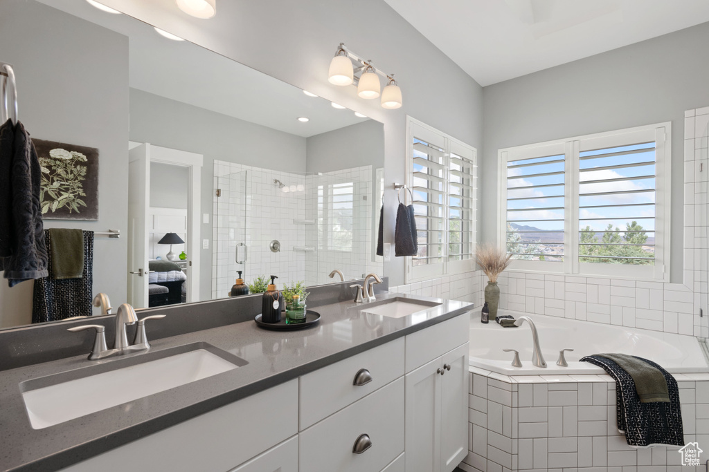 Ensuite bathroom featuring a garden tub, double vanity, and a tile shower