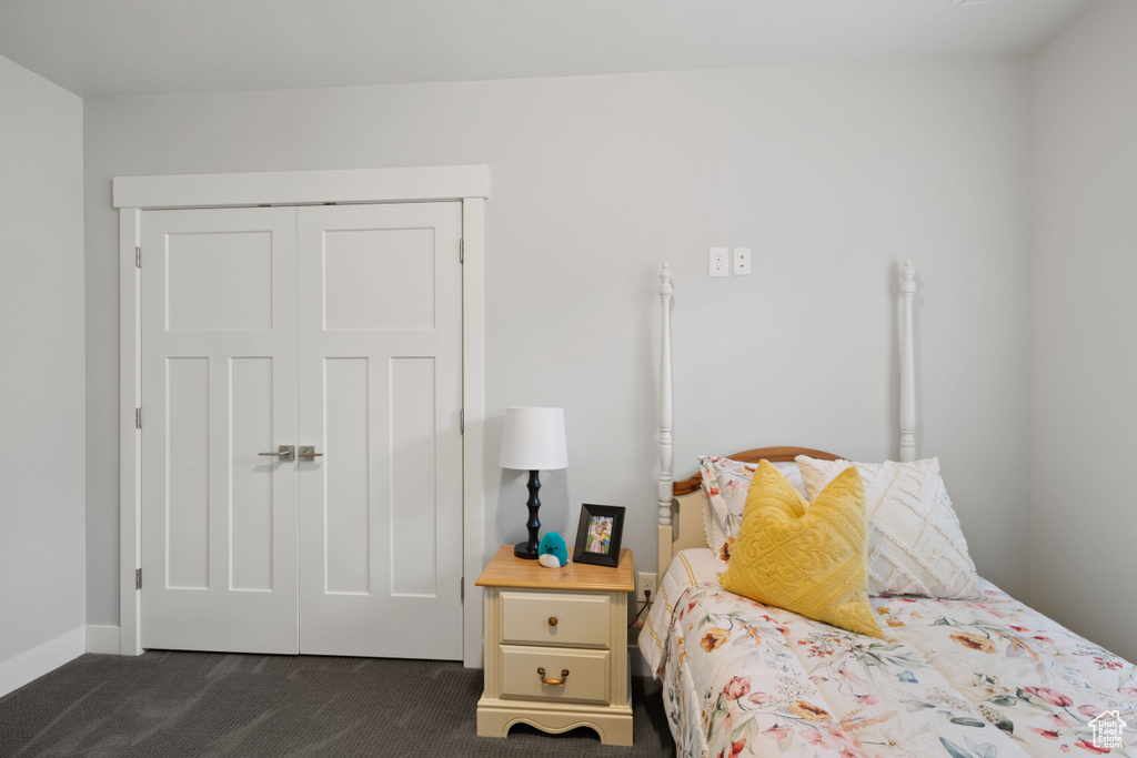 Bedroom featuring dark colored carpet and a closet