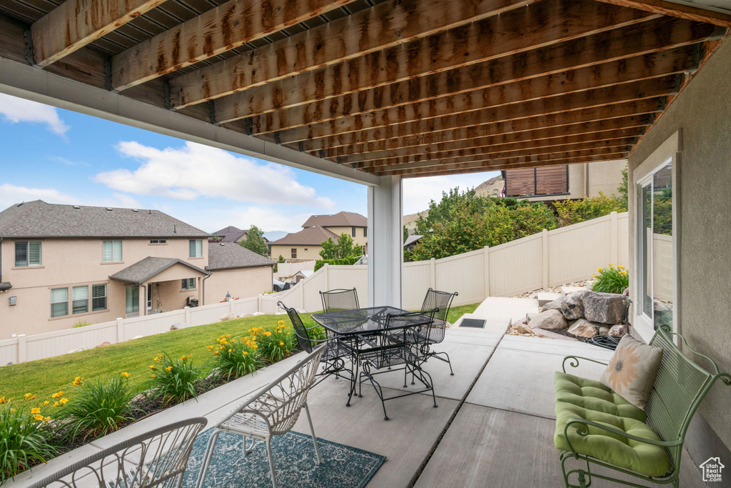Fenced backyard with a patio, outdoor dining area, and a residential view