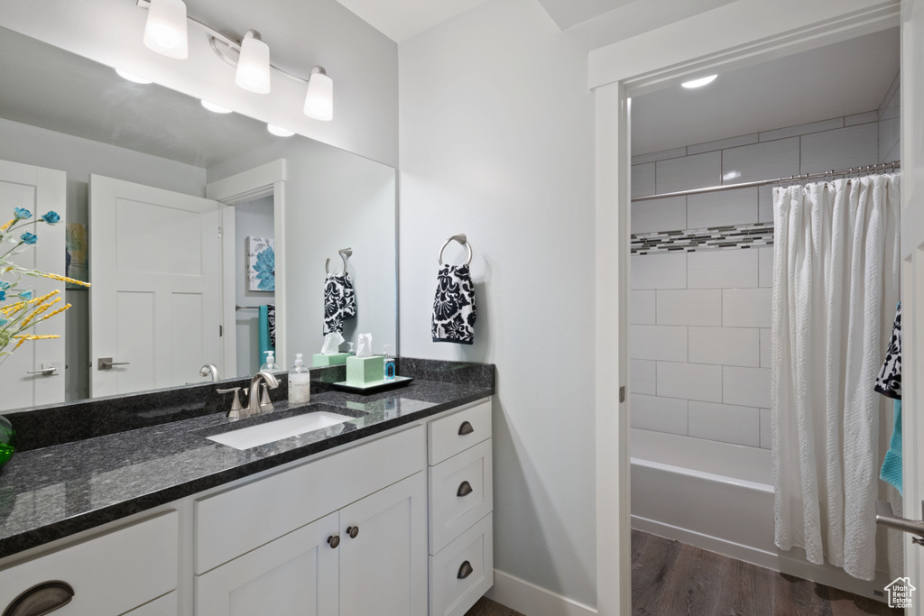 Full bathroom featuring vanity, wood finished floors, and shower / bath combination with curtain