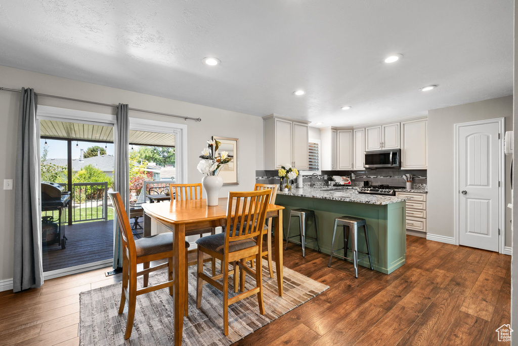 Dining space with dark wood-type flooring and recessed lighting