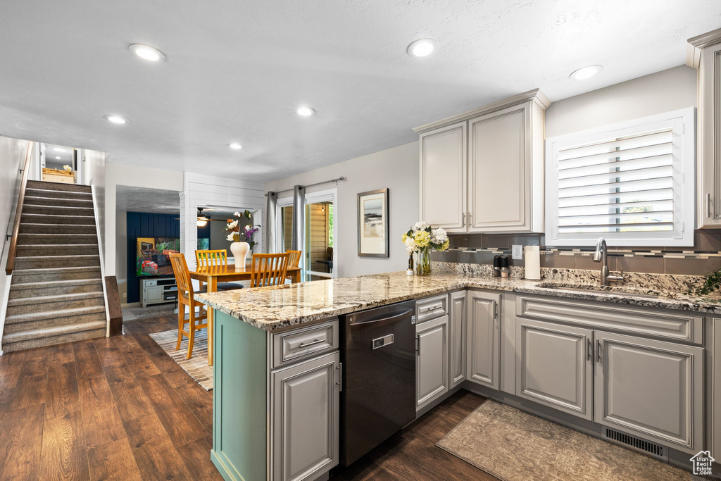 Kitchen featuring dishwashing machine, a peninsula, gray cabinetry, dark wood finished floors, and recessed lighting