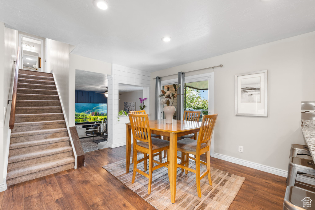 Dining room featuring decorative columns, stairway, wood finished floors, and recessed lighting