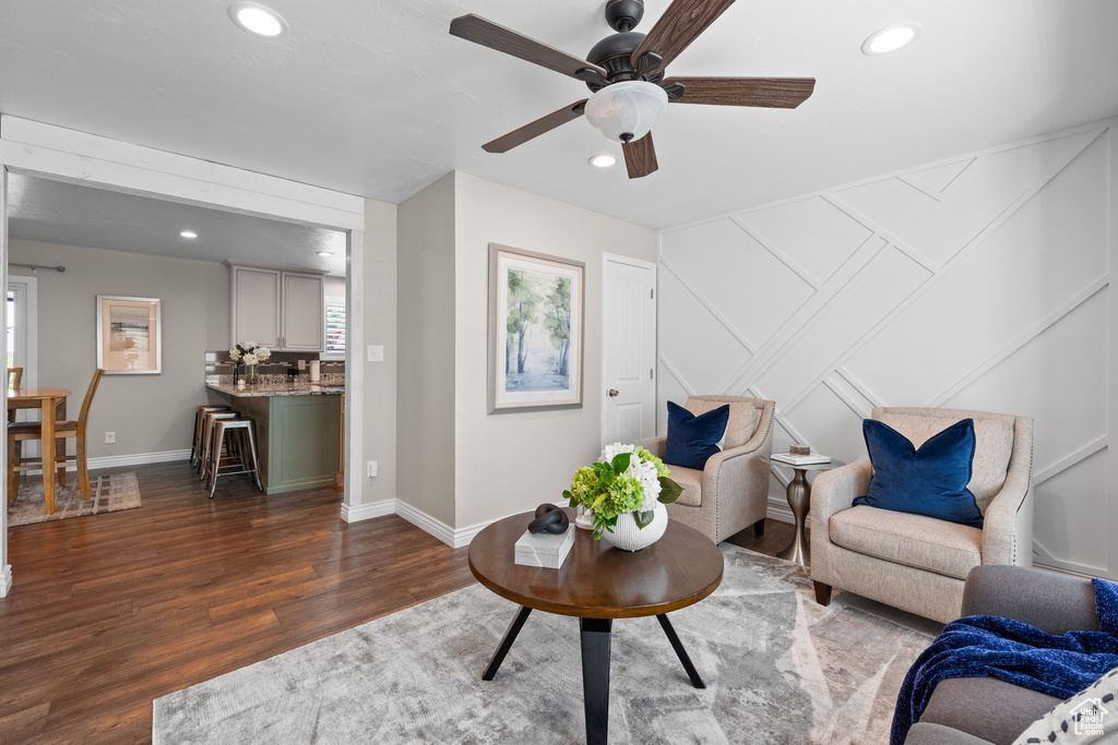 Living area with recessed lighting, wood finished floors, a ceiling fan, and a decorative wall