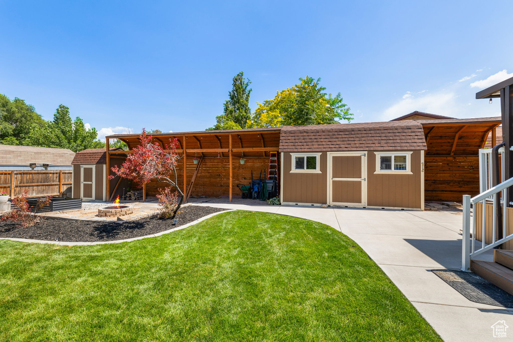 View of yard with a shed and a fire pit