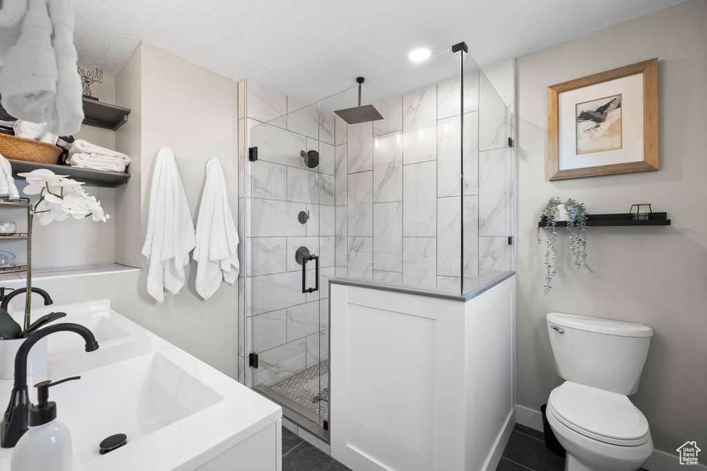 Bathroom featuring a shower stall and double vanity