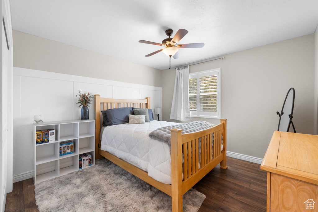 Bedroom with dark wood-type flooring and a ceiling fan