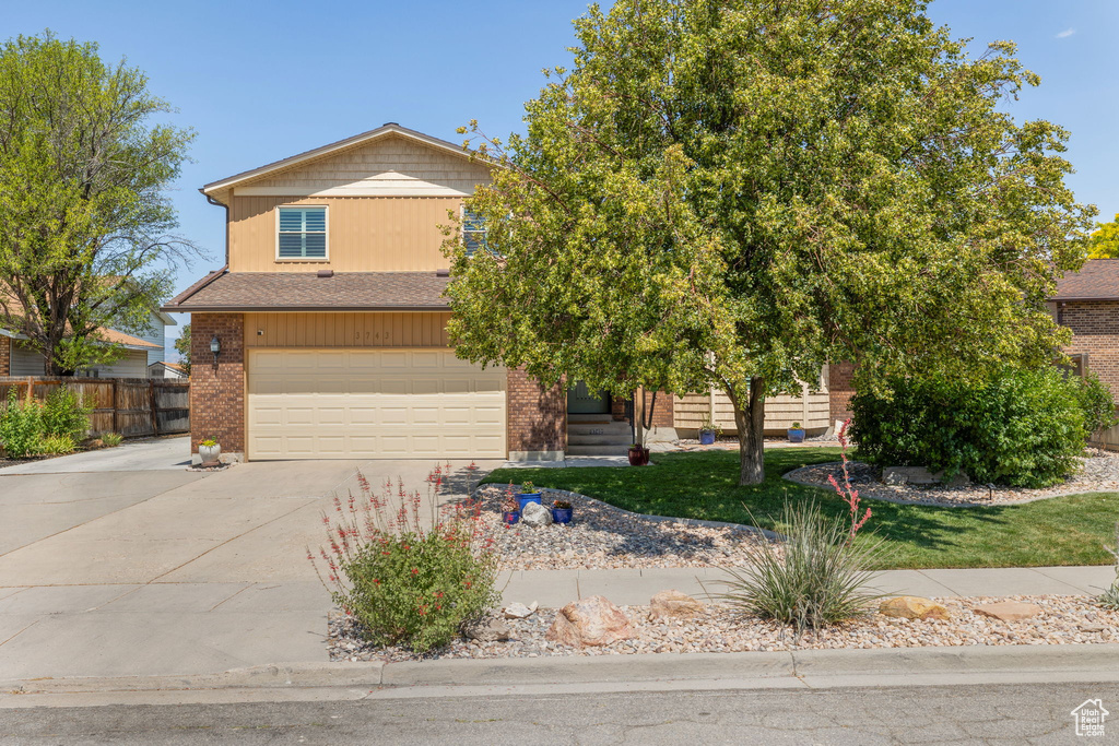 View of front facade with concrete driveway, an attached garage, and brick siding