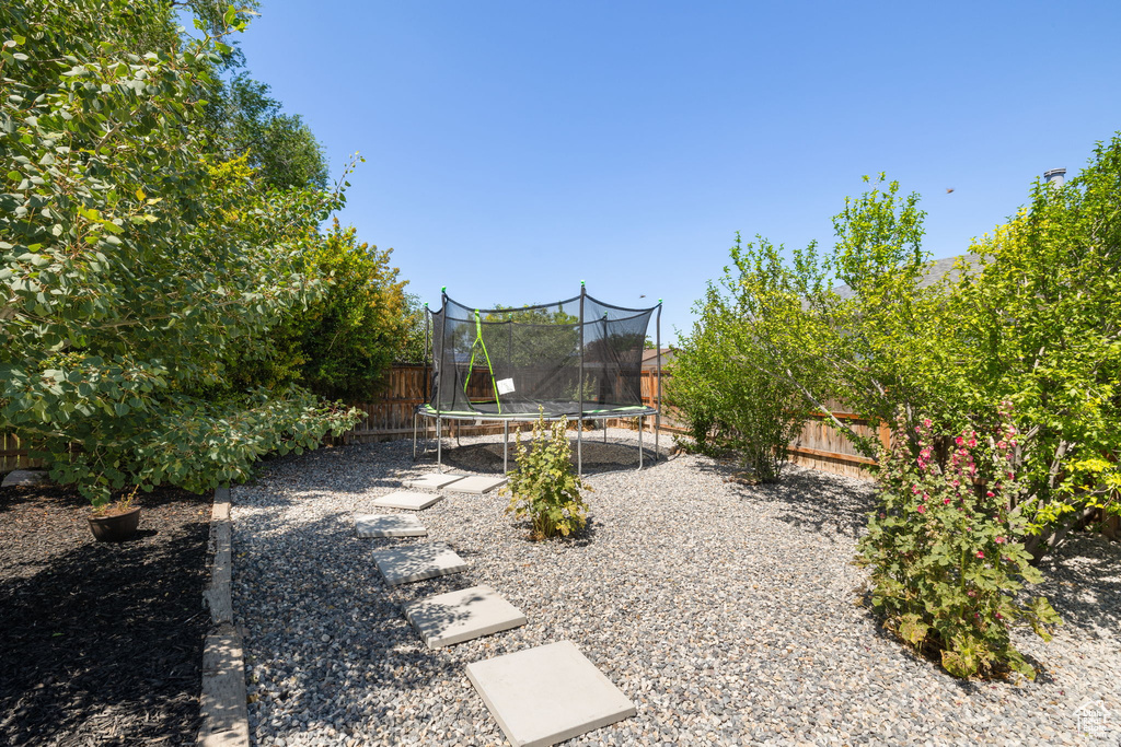 Fenced backyard with a trampoline