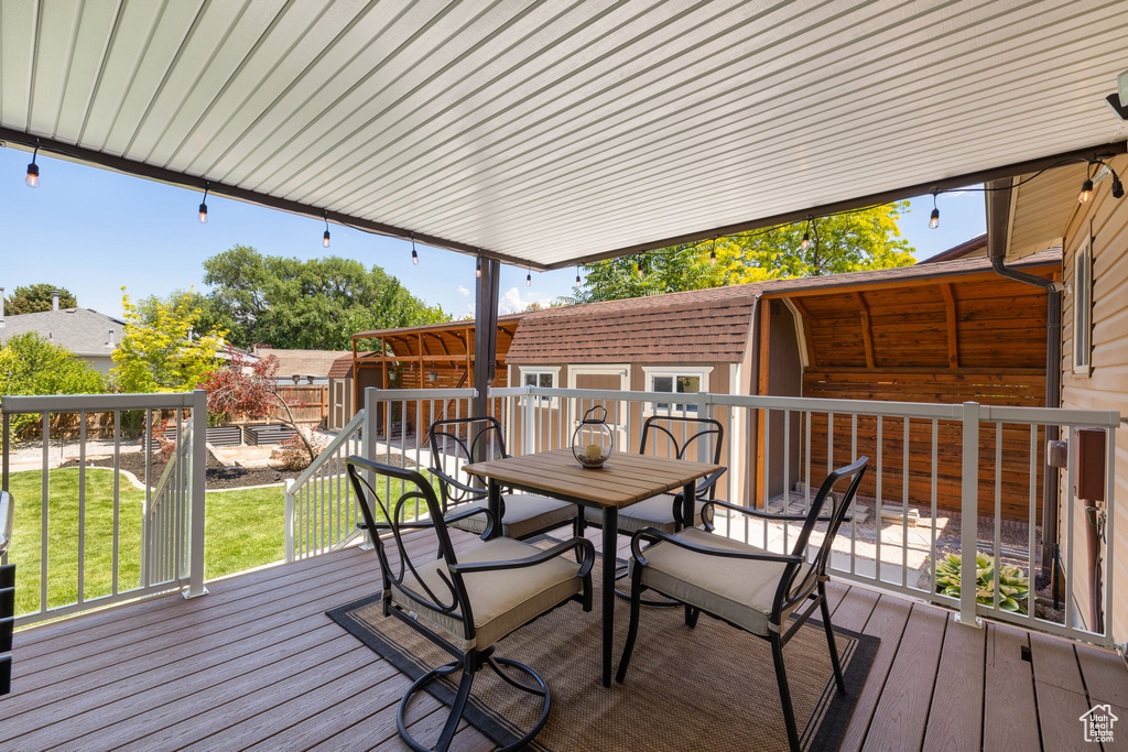 Deck featuring outdoor dining space and a shed