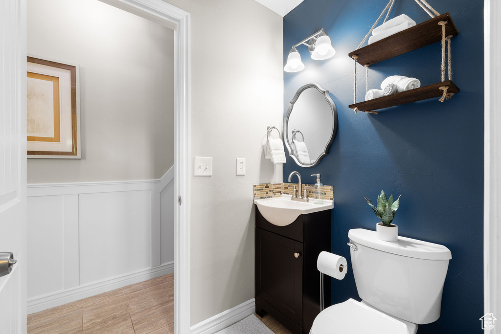 Half bathroom featuring vanity and a wainscoted wall
