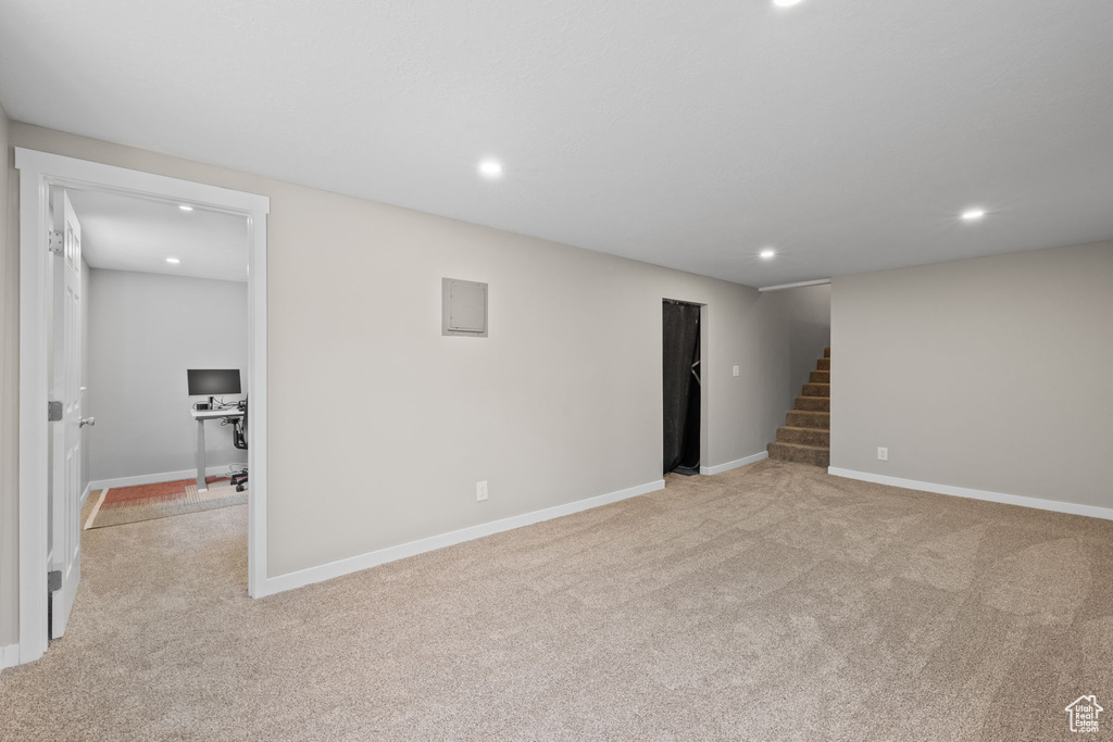 Spare room with light colored carpet, stairway, recessed lighting, and a desk