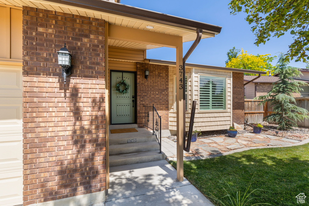 Doorway to property featuring brick siding
