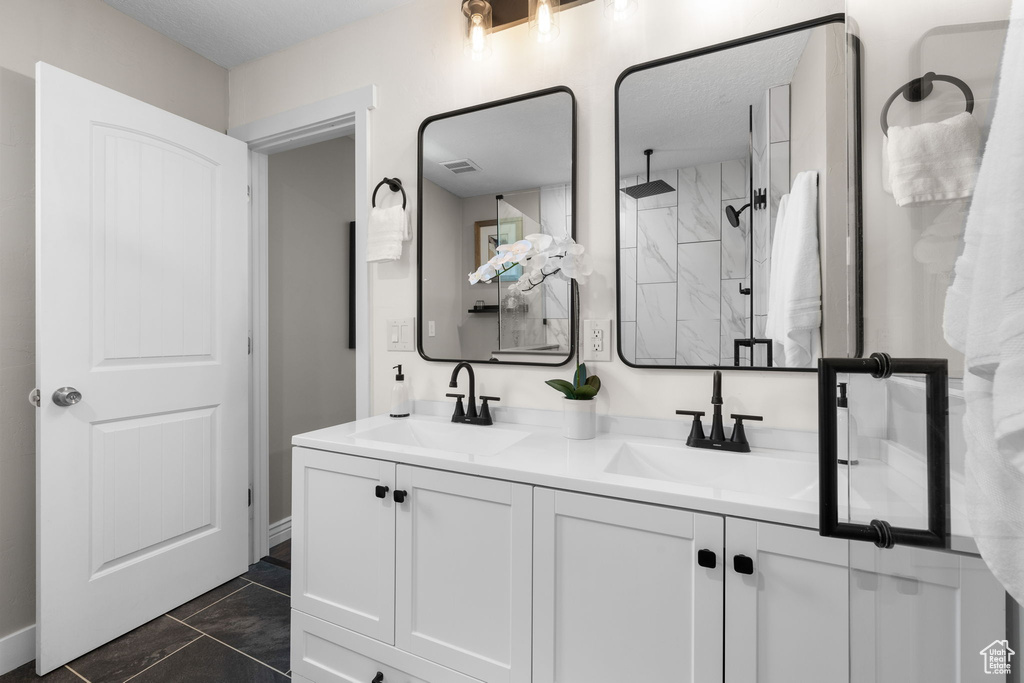 Full bathroom featuring double vanity and a walk in shower