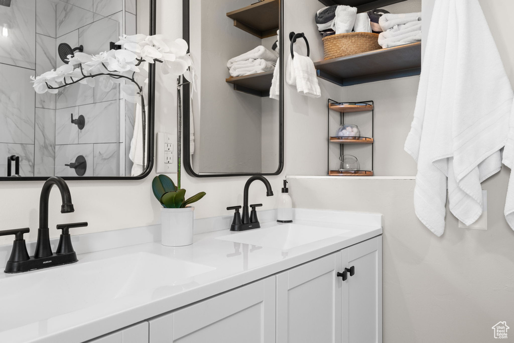 Bathroom with double vanity and tiled shower