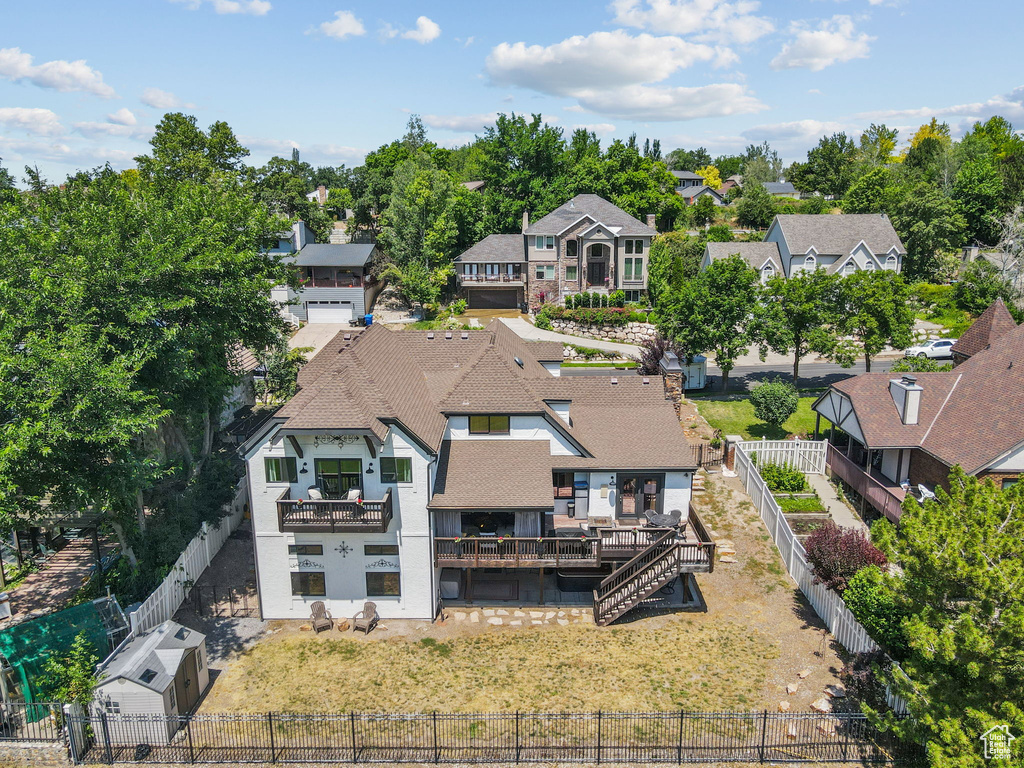Rear view of property featuring a residential view, a fenced backyard, a balcony, and stucco siding