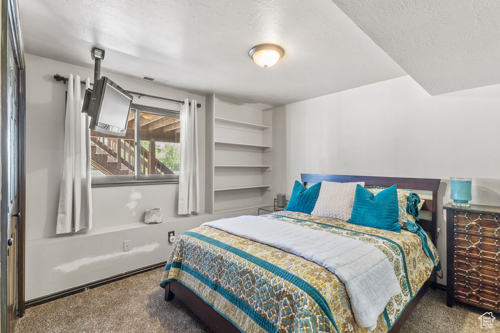 Bedroom featuring carpet flooring and a textured ceiling