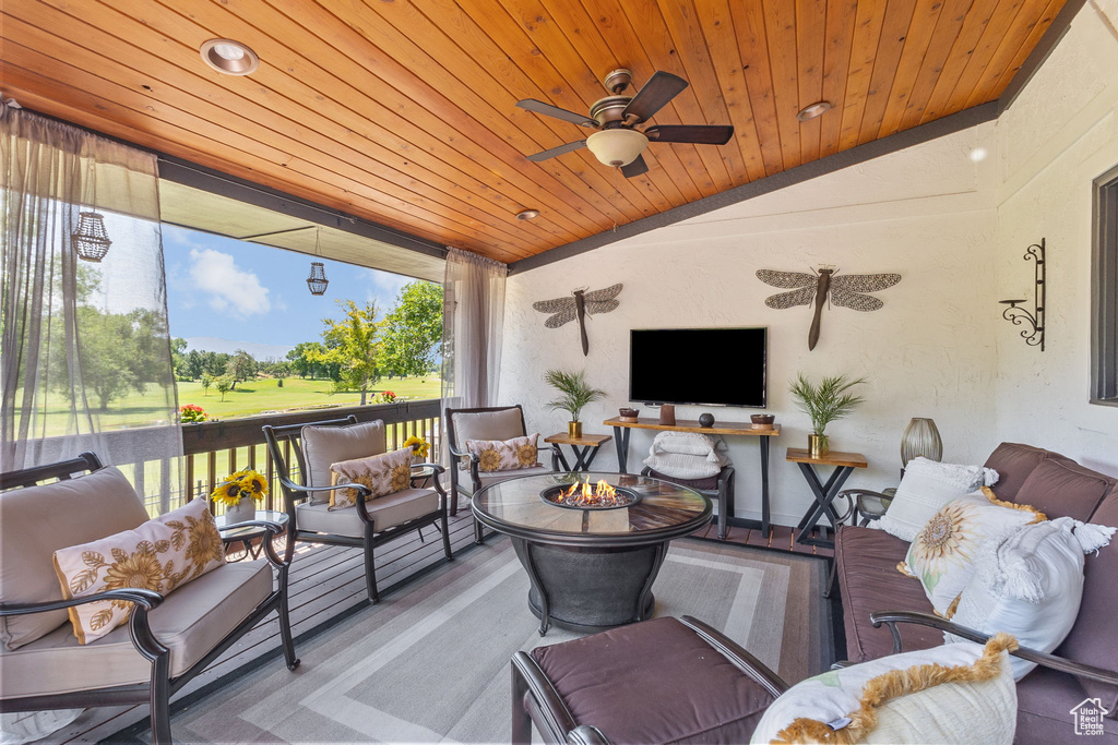 Deck featuring an outdoor living space with a fire pit and a ceiling fan
