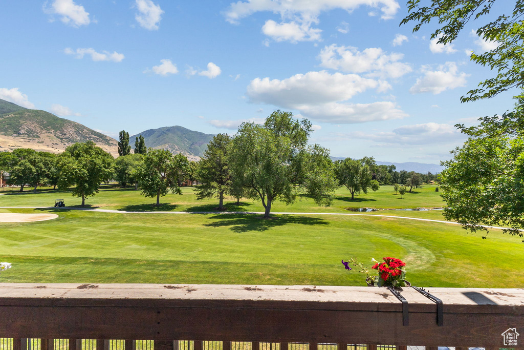 View of home\'s community with a mountain view, view of golf course, and a yard