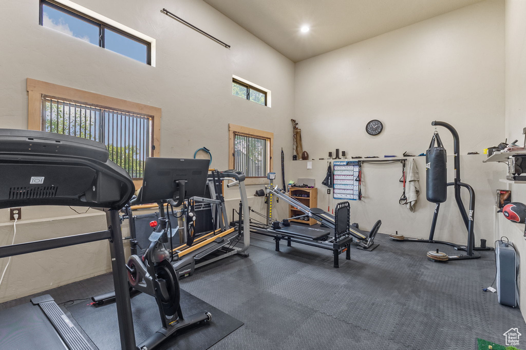 Gym with healthy amount of natural light and a towering ceiling