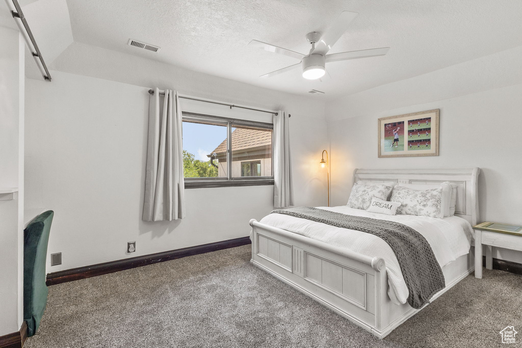 Bedroom featuring carpet flooring, a textured ceiling, and a ceiling fan
