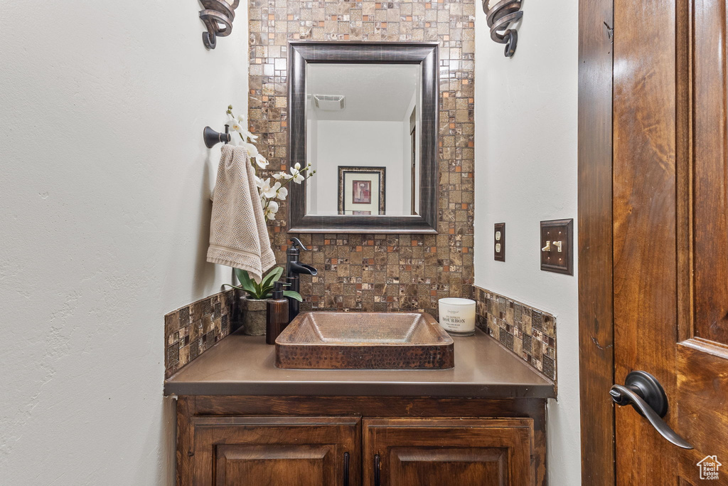 Bathroom featuring vanity and tasteful backsplash