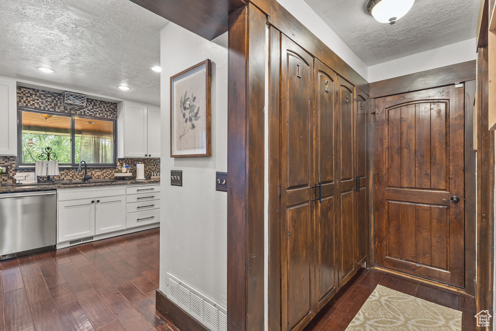 Hall with a textured ceiling, dark wood-type flooring, and recessed lighting