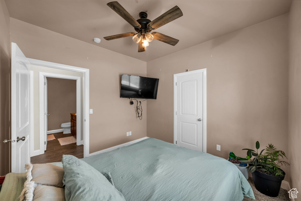 Bedroom with wood finished floors, ceiling fan, and ensuite bathroom