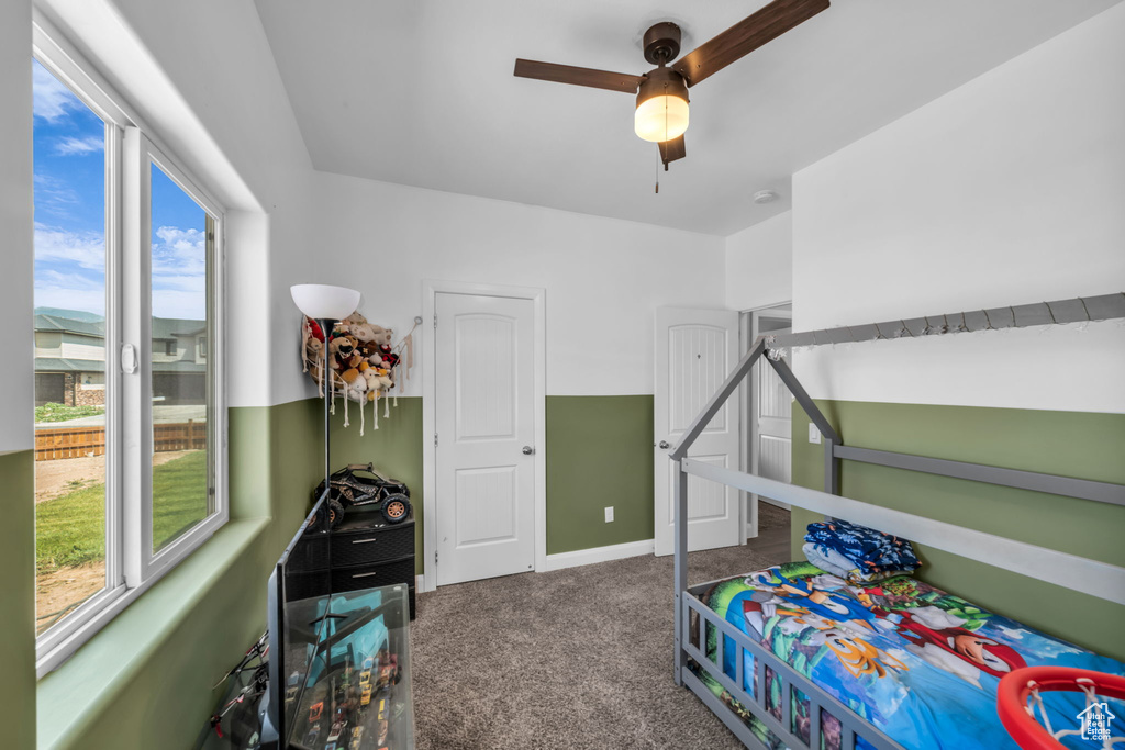 Carpeted bedroom featuring ceiling fan