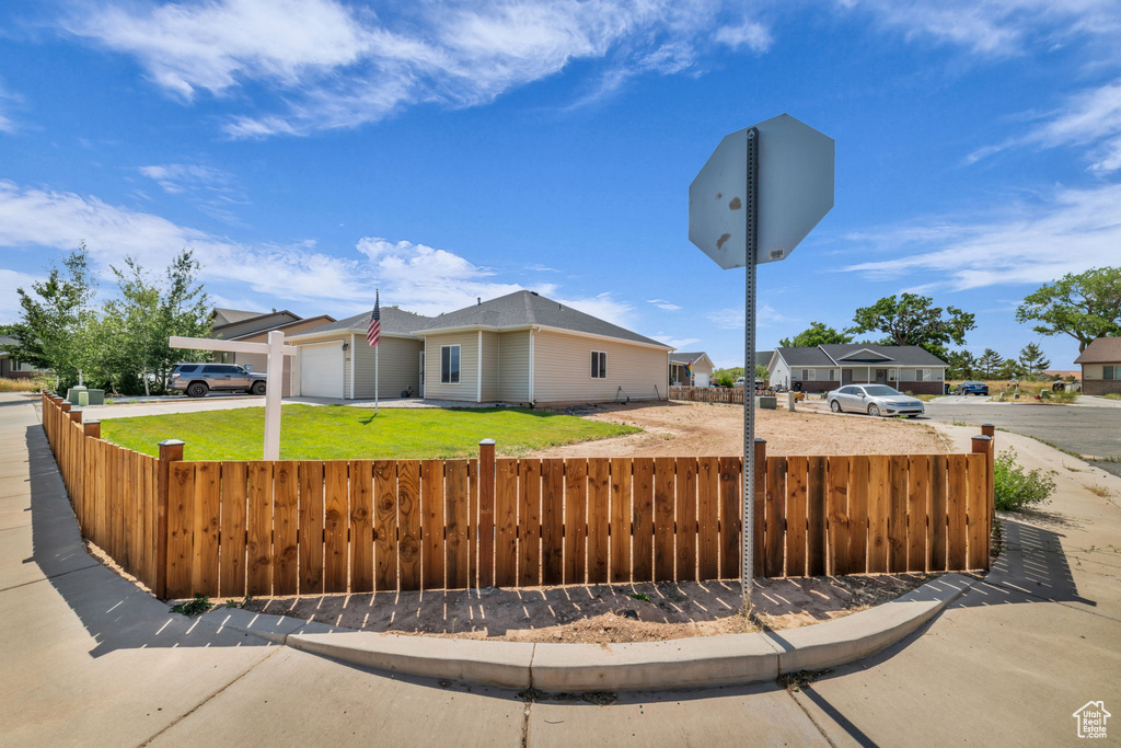 View of front facade featuring an attached garage, driveway, and a residential view