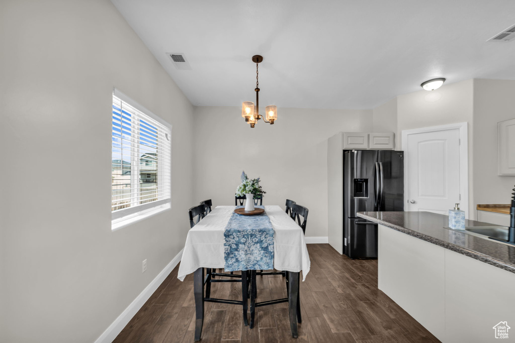 Dining area featuring a chandelier and dark wood-style floors