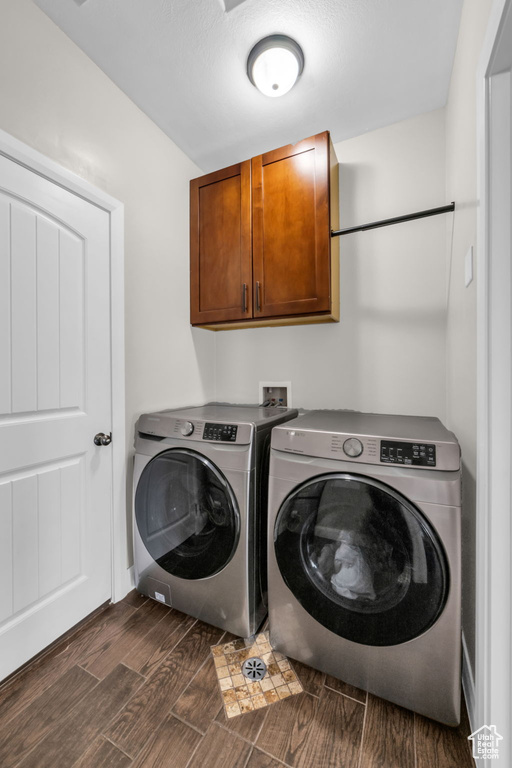 Washroom featuring cabinet space, independent washer and dryer, and wood finish floors