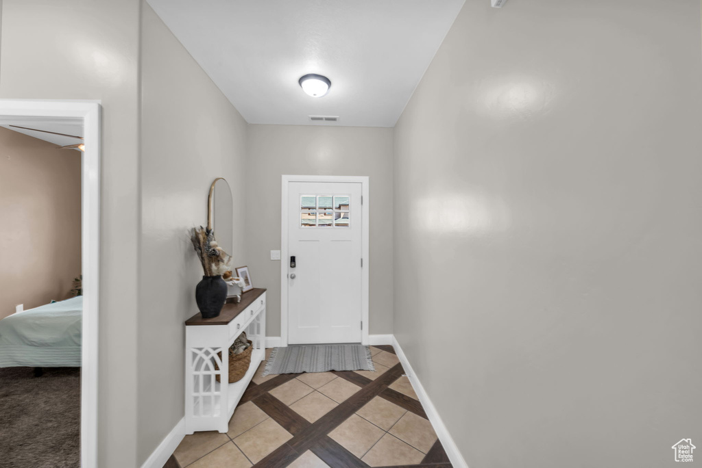 Entryway featuring inlaid floor details and light tile patterned floors