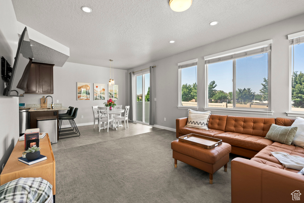 Living room with plenty of natural light, a textured ceiling, and recessed lighting