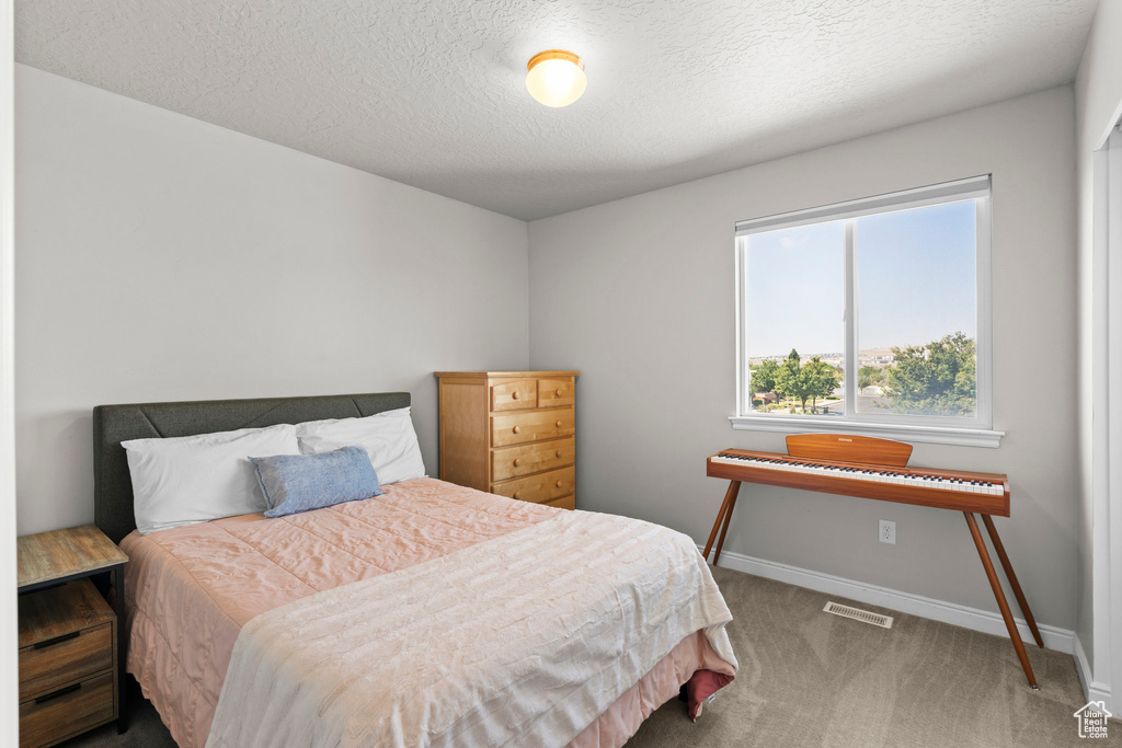 Bedroom with carpet and a textured ceiling