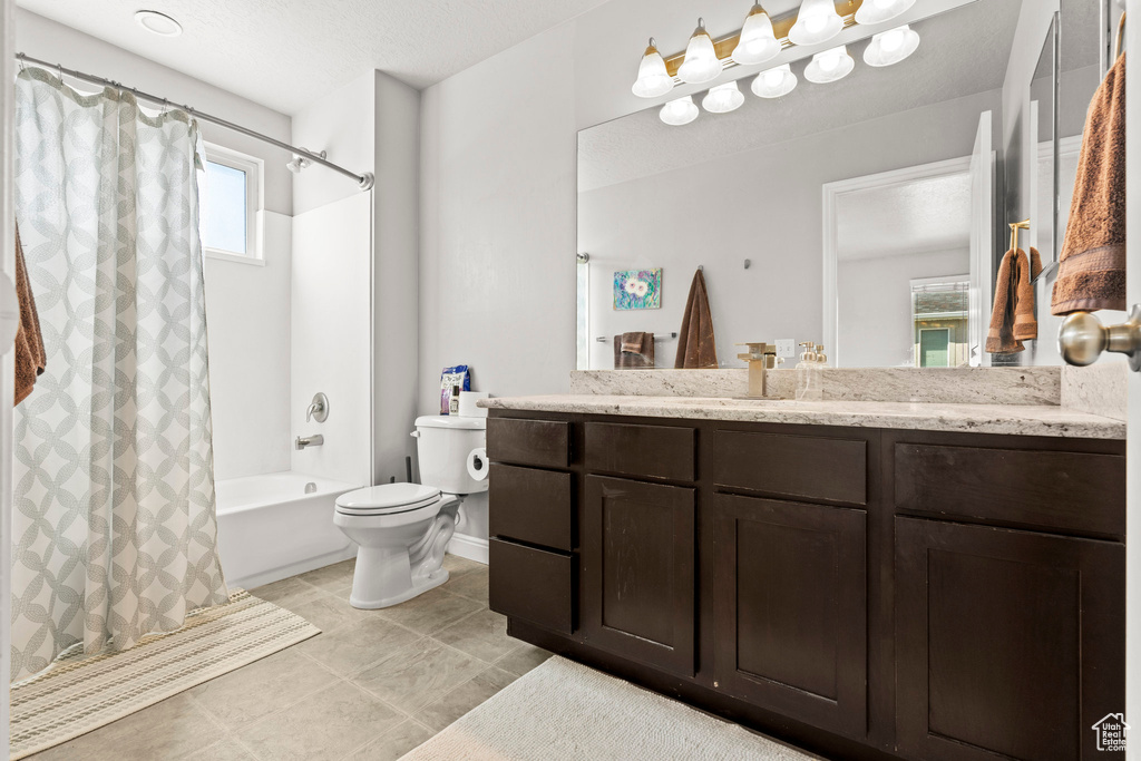 Bathroom featuring shower / bath combo, vanity, and tile patterned flooring