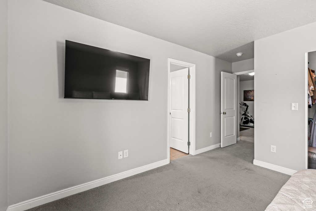 Unfurnished bedroom with carpet floors and a walk in closet