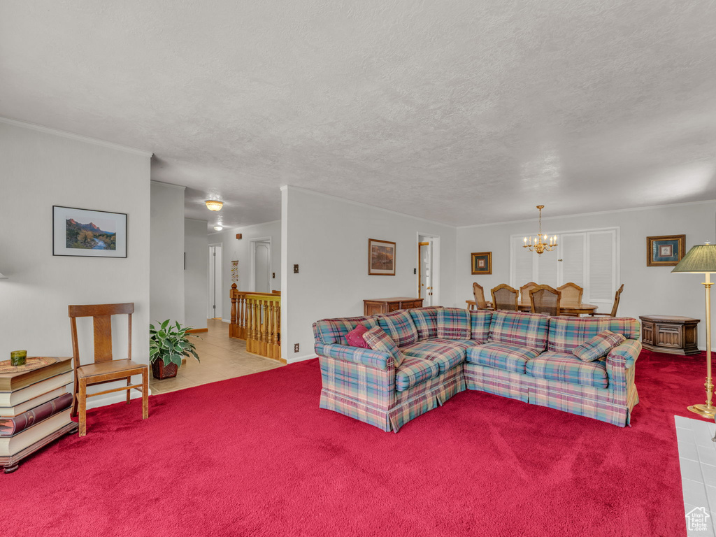 Living room with carpet floors, a chandelier, and a textured ceiling