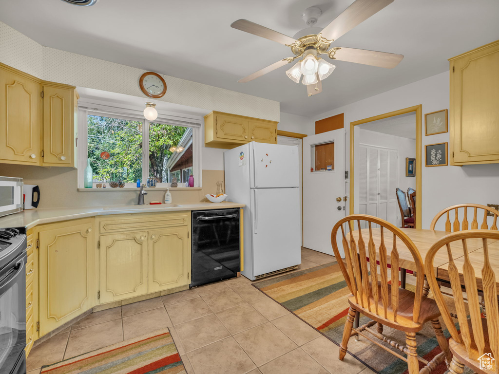 Kitchen featuring white appliances, light countertops, light tile patterned floors, and a ceiling fan