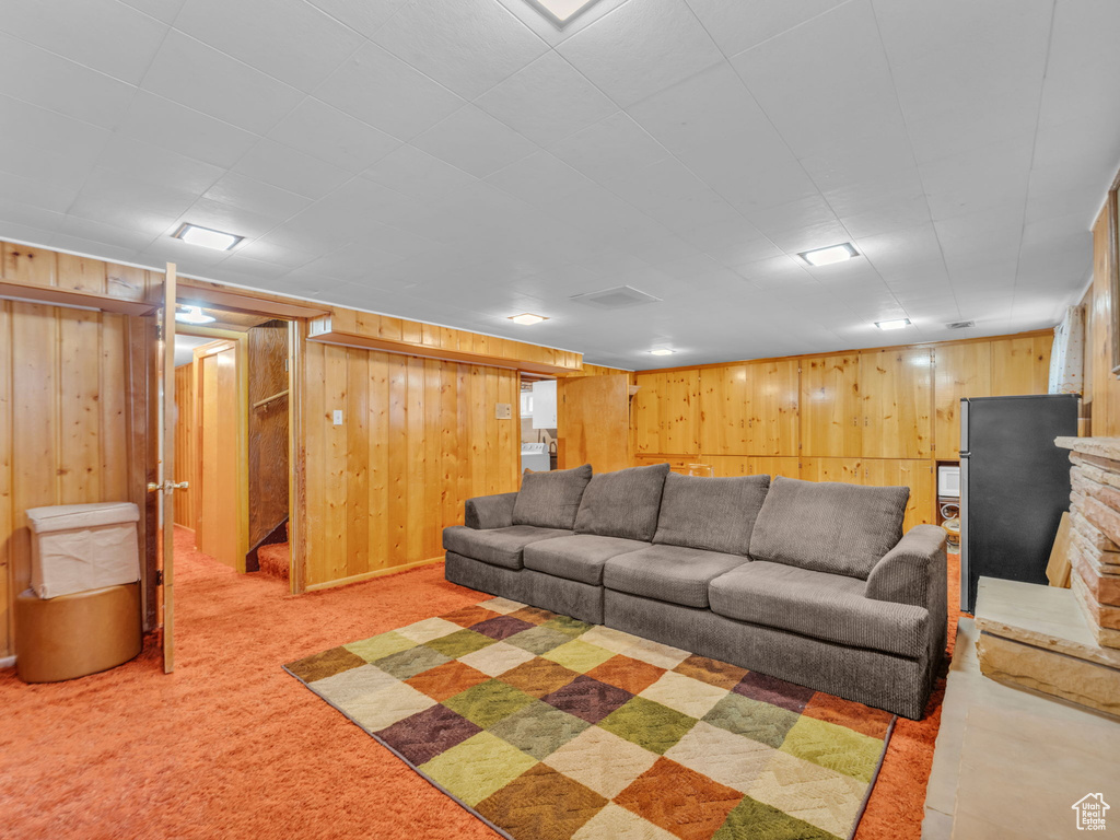 Living room featuring wood walls and light colored carpet