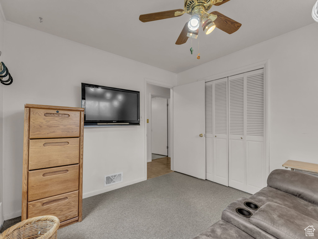 Living area with ceiling fan and carpet floors