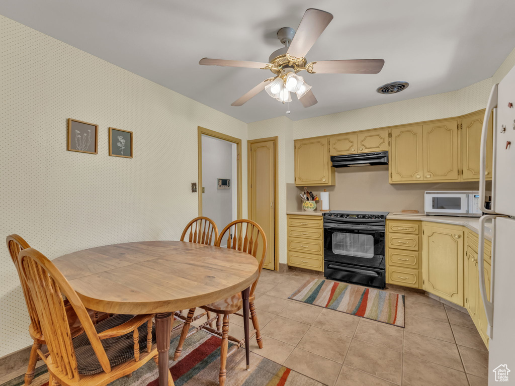Kitchen featuring white appliances, under cabinet range hood, light countertops, light tile patterned floors, and a ceiling fan